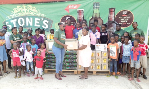 Aba Bilson, Secretary, T T Brothers Ltd, presenting the items to Suzie Dzre, a mother representative of the Tema SOS Village