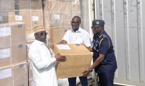 Emmanuel Ohene (right), Deputy Commissioner, Customs Division of GRA, with George Winful (middle), Director, Revenue Policy Division, Ministry of Finance, handing over a box of the medical supplies to Alhaji Hafis Adam (left), Chief Director, Ministry of Health