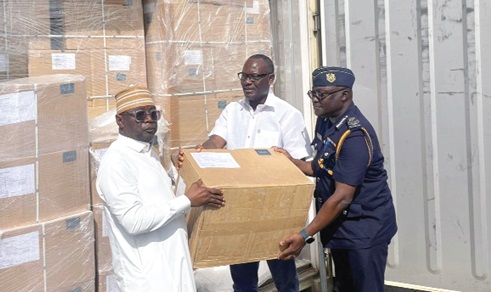 Emmanuel Ohene (right), Deputy Commissioner, Customs Division of GRA, with George Winful (middle), Director, Revenue Policy Division, Ministry of Finance, handing over a box of the medical supplies to Alhaji Hafis Adam (left), Chief Director, Ministry of Health
