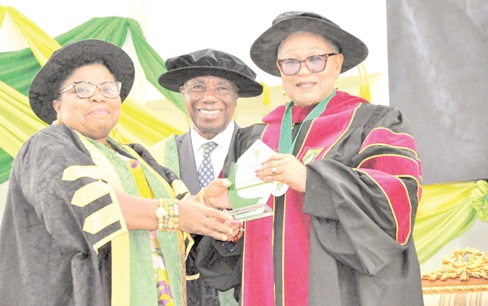 Professor Lydia Aziato (left), Vice Chancellor of UHAS, presenting the citation to Rev Dr Joyce Aryee, Executive Director of Salt and Light Ministries, with the citation, while Justice Jones Dotse, Chairman of UHAS, looks on with a smile