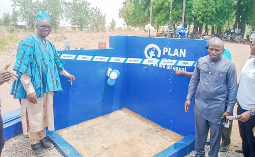 Contant Tchona (left), Country Director of Plan International Ghana, with Yidana Zakaria (right), North East Regional Minister, testing the taps