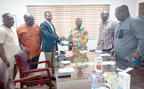 Henry Kwadwo Boateng (3rd from right), President, Institution of Engineering Technology-Ghana, exchanging a document with Awal Sakib Mohammed, President, Ghana Electrical Contractors Association. Looking on are members of both organisations