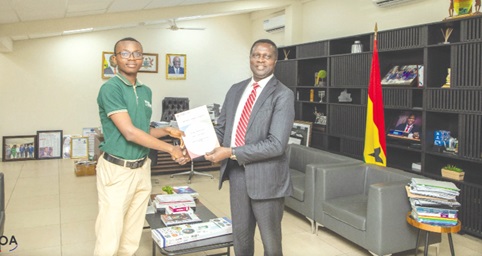Dr Yaw Osei Adutwum (right), Minister of Education, presenting the certificate to Kofi Kokua Asante Anyimadu