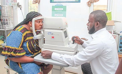 Dr Haryana Yakubu Zato, an Optometrist at the LeKMA Hospital, screening the eye of a woman