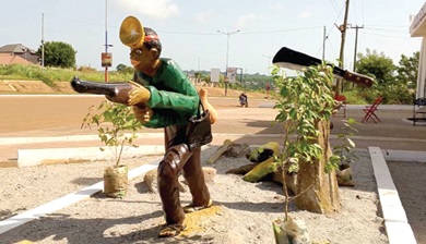 A sculpture of a hunter with a gun erected in front of the Nana Bosoma Asor Nkrawiri II Royal Palace A sculpture of a hunter with a gun erected in front of the Nana Bosoma Asor Nkrawiri II Royal Palace