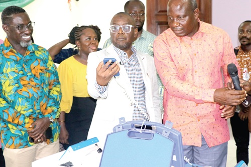 Alhaji Hafiz Adam (2nd from right), Chief Director, Ministry of Health, examining one of the equipment at the  Calibration Centre in Accra. On his left is Kwame Sarfo, Deputy Director of Infrastructure, Ministry of Health