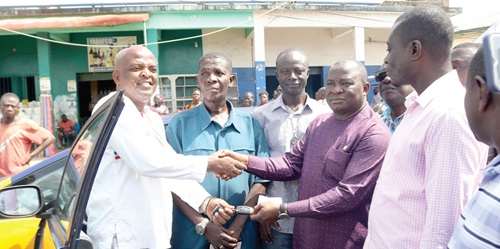 Akwasi Acquah (2nd from right), MP for Akyem Oda, presenting the keys to a vehicle to one of the beneficiary taxi drivers. INSET: A fleet of the taxis             