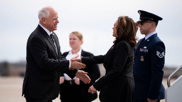 Kamala Harris in a warm handshake with Tim Walz