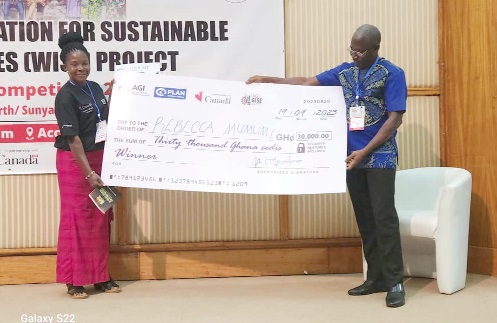 Rebecca Mumuni receiving her prize from Eric Ayaba, Plan International Ghana Head of Programmes &amp; Influencing
