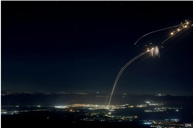 Dozens of rockets fired by Hezbollah were intercepted over northern Israel by the Iron Dome air defence system