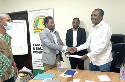 Ben Arthur (right), CEO, Fair Wages and Salaries Commission, and Peter Akudugi Ayamba, President of the Physician Assistants Association of Ghana, exchanging documents after signing the agreement