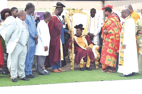  Prof. Prince Boateng (seated), Principal of the Ada College of Education, being presented with his sword by Dr Francis Boateng Agyenim (with the microphone), College Governing Council Chairman