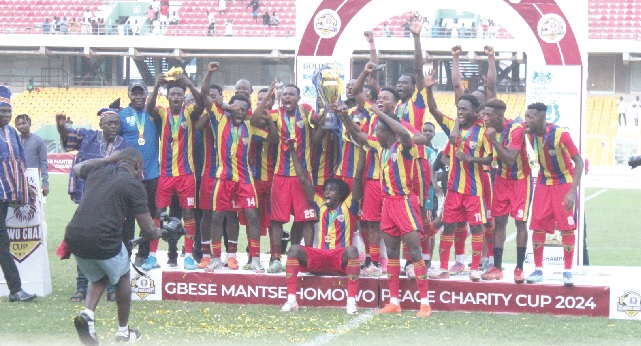 Players and officials of Hearts of Oak celebrating with the Gbese Mantse Homowo Peace Charity Cup after their shootout victory over Kpando Heart of Lions. Pictures: ERNEST KODZI