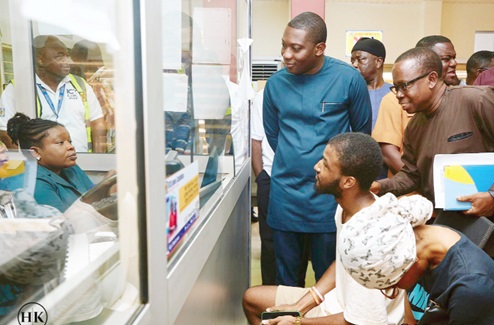 Herbert Krapa, Minister of State, Ministry of Energy, interacting with a customer services officer of the ECG