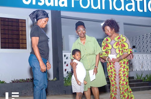 Ursula Owusu Ekuful (middle), Minister of Communications and Digitilisation, presenting a token to a child with special needs after the evening with guardians and persons with special needs event