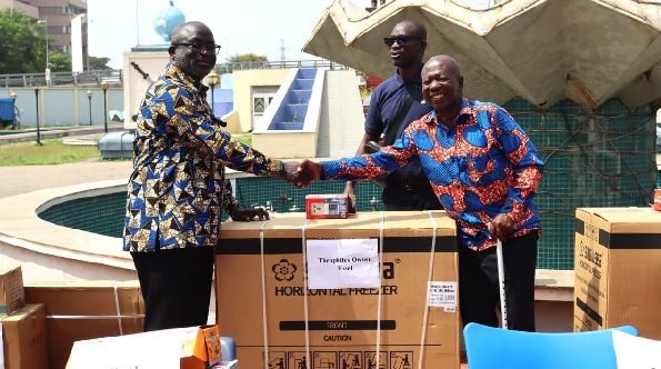 Samuel Nii Adjei Tawiah (left), MCE of KoKMA presenting one of the freezers to one of the beneficiaries, Theophilus Owusu Essel