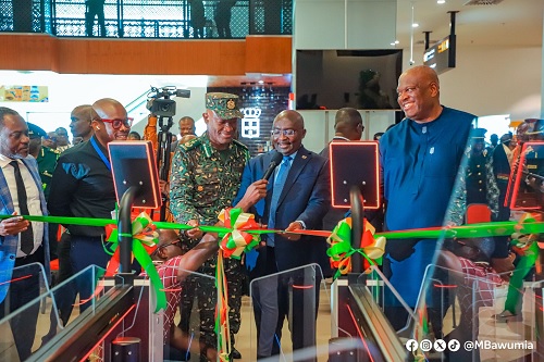 Dr Mahamudu Bawumia (2nd from right) being assisted by Kwame Asuah-Takyi (2nd from left), Comptroller-General of the GIS, and Henry Quartey (right), Minister for the Interior, to cut the tape for commissioning of the e-gate