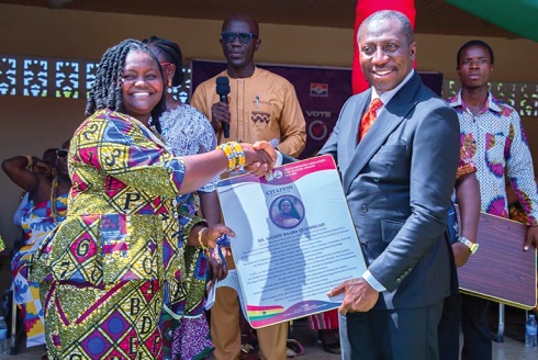 Alexander Afenyo-Markin (right),  MP for Effutu, handing over a citation to Mandy Baaba Quarshigah, a teacher at St Don Bosco Catholic Primary Girls KG, one of the award recipients