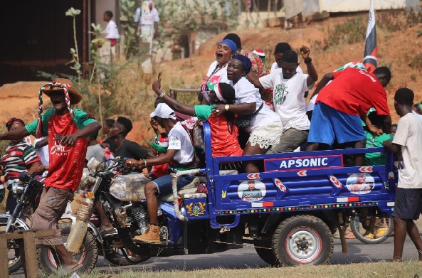 Some NDC supporters in a bucket of a tricycle popularly known as Aboboyaa in Kumasi, jubilating