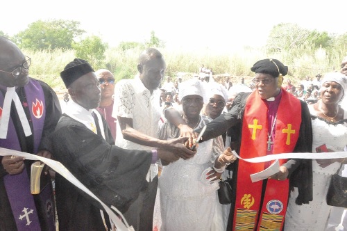 Rt Rev. Dr Bliss Agbeko (right) and other clergymen and members of the church assisting Madam Felicia Logo (middle) in performing the tape-cutting ceremony before the dedication service. left: The Akorfafa EPCG Chapel at Mafi-Tsati