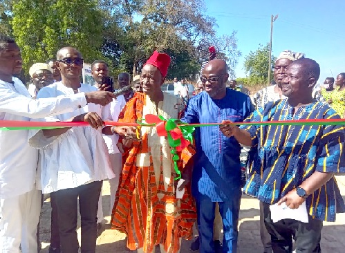 Benjamin Anane (2nd from right), Deputy Chief Executive Officer, GTA, being assisted by Pe Thomas Aluah Asangchira, Chief of Kasigu, and other dignitaries cutting the tape to inaugurate the project