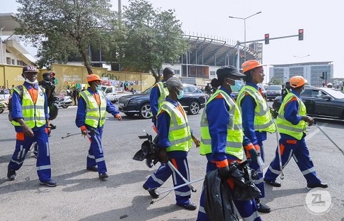  Some workers of Zoomlion after tidying up the Black Star Square. INSET: The streets as of yesterday morning. Picture: DIANA MENSAH