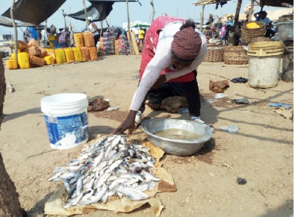 One of the traders preparing fresh fish on the dusty ground