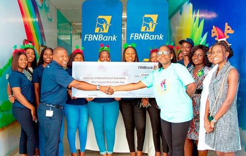 Allen Quaye (left), Head, Retail Banking, FBNBank Ghana Limited, presenting the cheque to Akua Sarpong, Executive Director, Lifeline for Childhood Cancer Ghana. Looking on is a cross-section of FBNBank Ghana Staff and health professionals of the Paediatric Oncology Unit of the Korle Bu Teaching Hospital.   