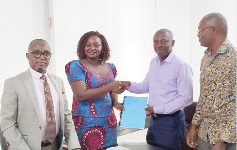 Justina Marigold Assan (2nd from left), Central Regional Minister, handing over a copy of the performance contract to Willy Evans Obiri-Awuah, District Chief Executive for Abura Asebu Kwamankese. With them is Michael Owusu Amoako (left) the Central Regional Coordinating Director, and Dr John Agbemenu Nunya (right), AAK Coordinating Director 