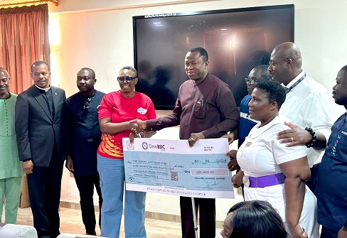 Sophia Kudjordji (4th from left), the Chief Corporate Communication Officer of Jospong Group, presenting a dummy cheque to Dr Opoku Ware Ampomah (4th from right), the Chief Executive Officer of the KBTH