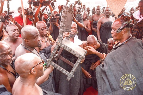 Nana Otuo Siriboe II, Juabenhene, receiving an ornamental chair which is one of the items that have been returned from the Fowler Museum in USA