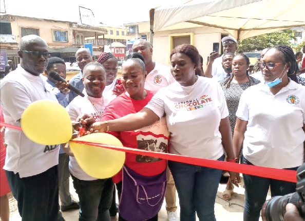 Dr Frank Asante (left), Director of Production at the Tema Cocoa Processing Company, with Michael Asumanu (2nd from left), Administrator of the Sunyani COCOBOD, and some staff cut the tape to inaugurate the cocoa products shop