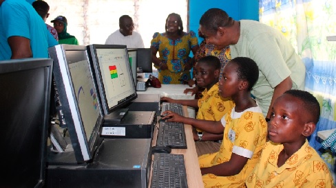 Mohammed Adamu Ramadan (standing right), MP for Adentan Constituency, with some pupils of the Holy Rosary Roman Catholic Basic School who were making use of the computers in the new laboratory