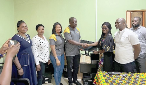Peter Bosrotsi (4th from left), Manager, HR Risk &amp; Operations, GCB Bank, presenting one of the computers to Sandra Asante, Head, Physiotherapy Department, Korle Bu Teaching Hospital