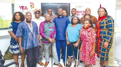 Kofi Baah Agyapong (middle), the Chief Executive Officer of YEA, with some PWDs after the meeting