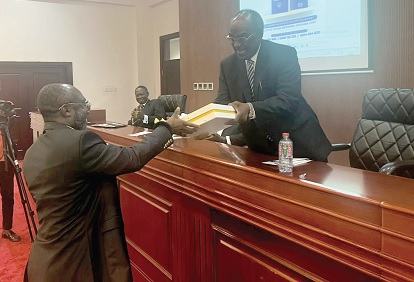 Barima Yaw Oppong Kodie (left), the Director of the Ghana School of Law, receiving the first auctioned copy of the book from Justice Prof. Date-Bah