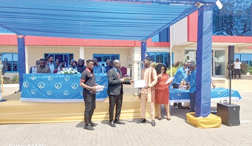 Prof. Alex Dodoo (2nd from left), Director-General,  GSA, presenting a certificate to Atteh Adamtey, a certified electrical wiring professional, at the graduation ceremony