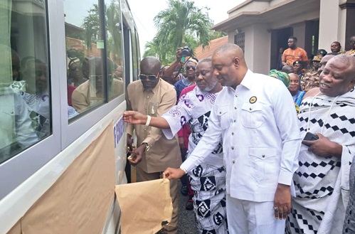 Daniel Nii Kwartei Titus-Glover (left), Greater Accra Regional Minister,  being supported by Prof. Nii Oboade Notse Odaifio Welentsi III (2nd from left), acting President of the Greater Accra Regional House of Chiefs, and Nii Tackie Teiko Tsuru II, President of the Ga Traditional Council, to unveil the bus donated by Vice-President Dr Mahamudu Bawumia