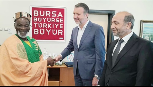 Cuneyt Sener, the Vice-President of the Chamber, presenting a souvenir to the Ya-Na. Looking on is a Board Member of the Bursa Chamber of Commerce