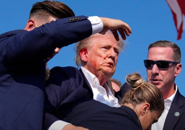 Republican presidential candidate former President Donald Trump is surrounded by Secret Service agents at a campaign rally on Saturday, July 13, in Butler, Pennsylvania. Evan Vucci/AP