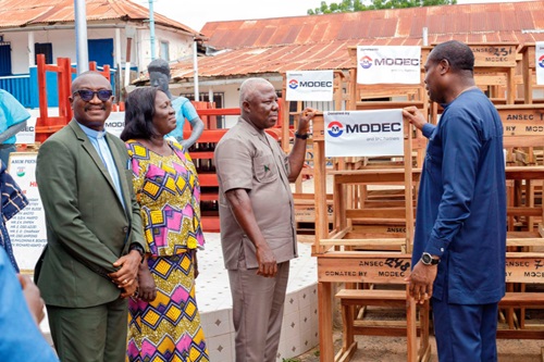  Theophilus Ahwireng (right), MD, MPSG, presenting the furniture to some officials from Anum Presby SHS