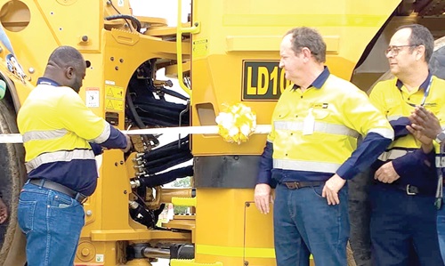 The diesel-electric loader. inset: Alex Kofi Annin (left), General Manager of the Ahafo South Mine, cutting the tape to unveil the diesel-electric loader. With him is Steven Scott (2nd from right), Managing Director of Mantrac Ghana