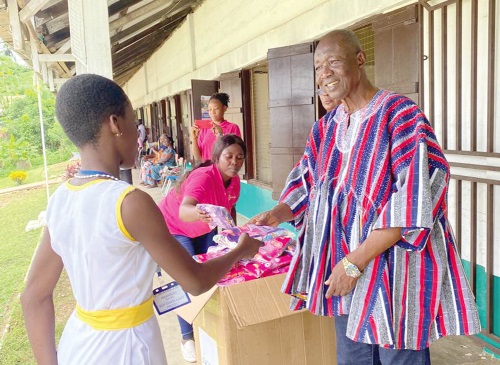 Obrempong Obeng Appiah, the Santanhene of Akyem Bosome Traditional Area, presenting some of the reusable sanitary pads to the schoolgirls