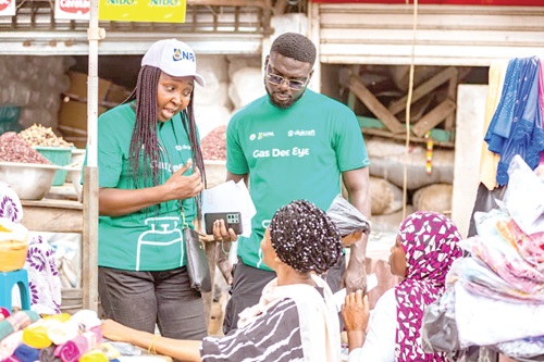 NPA officials educating some women on the Cylinder Recirculation Module and safe use of LPG at the market