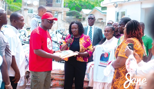 Prof. Naana Jane Opoku-Agyemang presenting documents on the motorbikes to Ekow Okyere Panyin Edumoah, acting Regional Chairman of the NDC