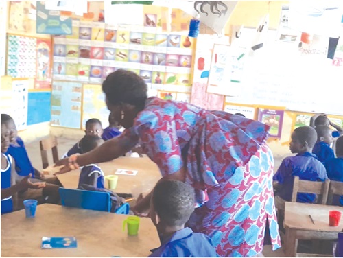 Agnes Sakyi-Djan, Headmistress of Donkorkrom Presby School, serving the children with a cup of milo and bread
