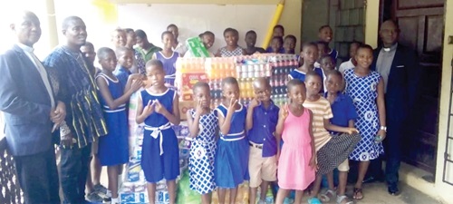Rev. Emmanuel Oklemey Tettey, the Somanya District Pastor of PCG, presenting the items to Christabel Adakwah, the foster mother of the orphanage Home