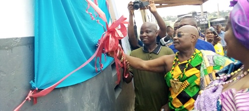 Barima Osafo Ntifo, (2nd from right), Abusuapanyin of Amanorkrom, being assisted by Ebenezer Yeboah Mireku, Secretary to the Okuapemman Fekuw of USA, to cut the ribbon to inaugurate the project