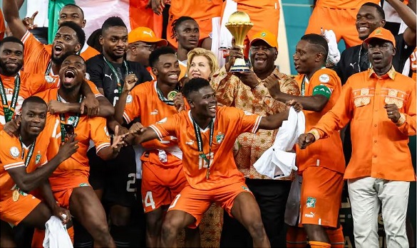 The Cote d'Ivoire team and President Alassane Ouattara (with trophy) celebrate with the AFCON trophy after victory over Nigeria in this year’s final