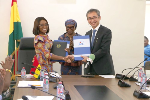 Ando Naoki, the Senior Vice-President of JICA, exchanging the signed grant agreement with Abena Osei-Asare (left), a Minister of State at the Ministry of Finance